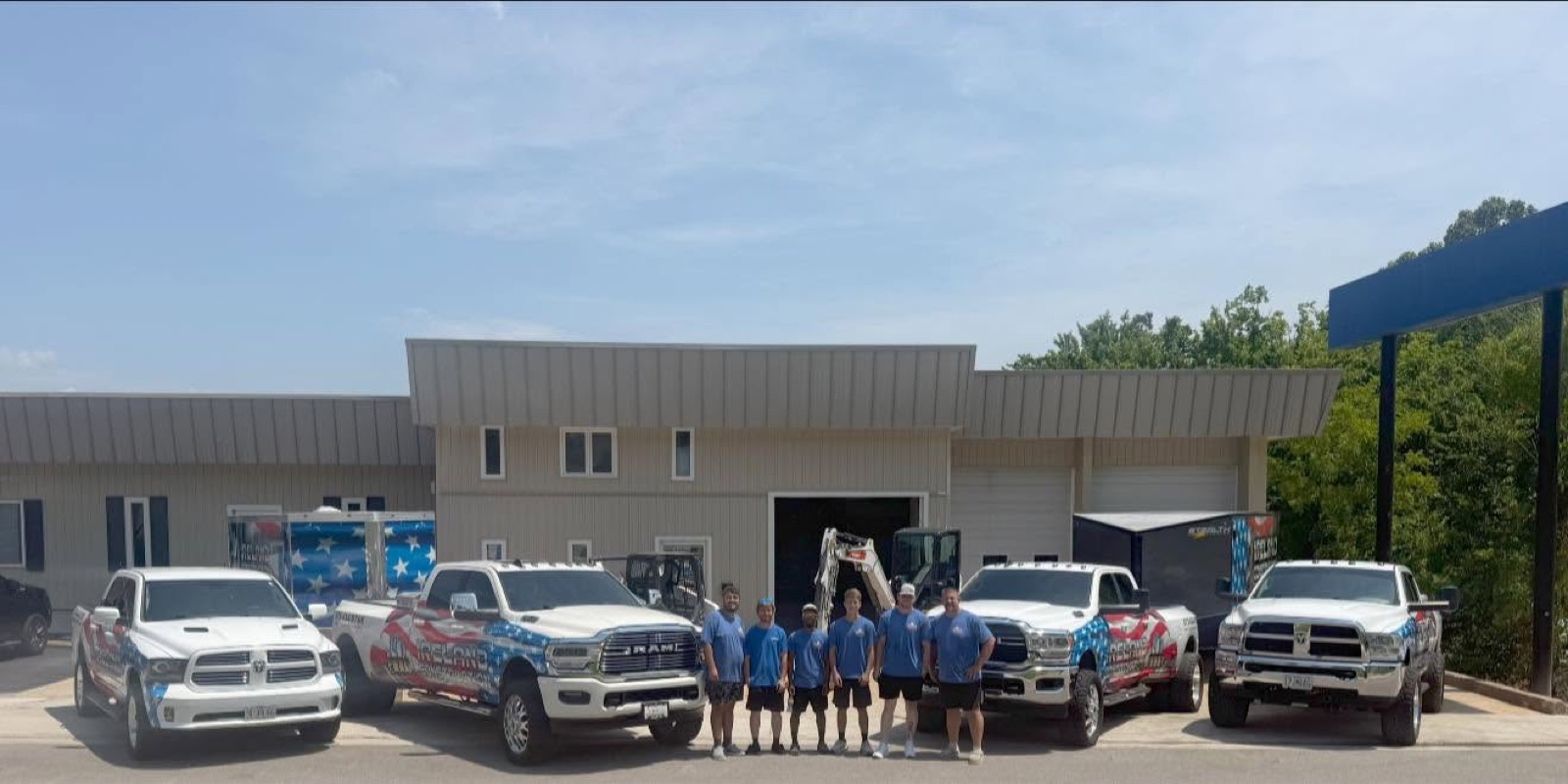 The Ireland Construction crew with their wrapped trucks and equipment outside the company shop