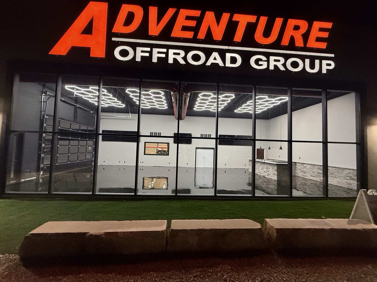 Night view of a lit commercial showroom through its full-height glass wall, built by Ireland Construction