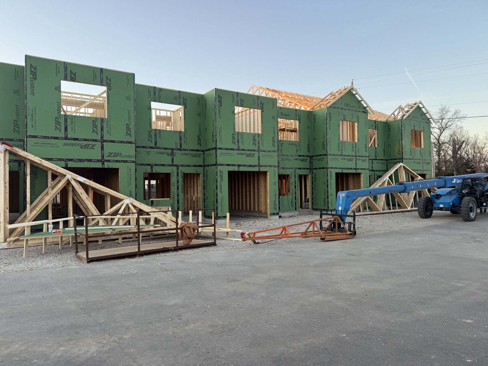 Roof trusses being set on a two-story building framed in weather sheathing by Ireland Construction