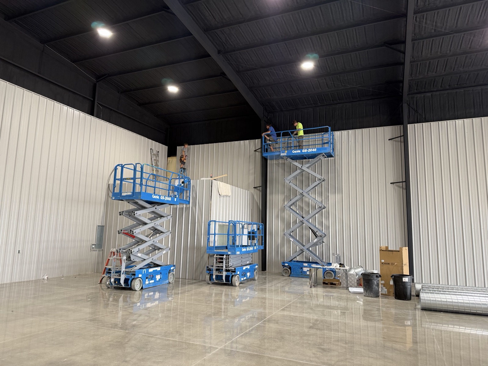 Ireland Construction crew on scissor lifts installing metal wall panels inside a steel building