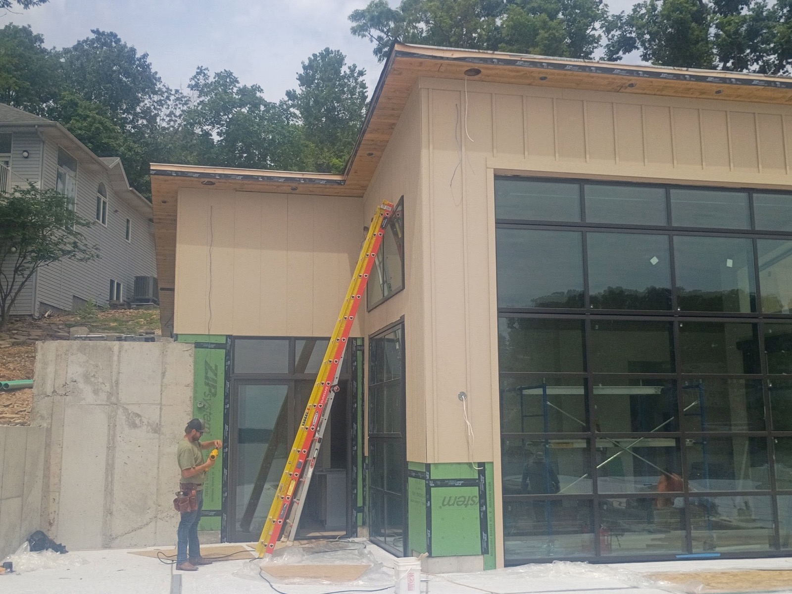 Ireland Construction crew member working on a modern custom build with floor-to-ceiling windows at Lake of the Ozarks