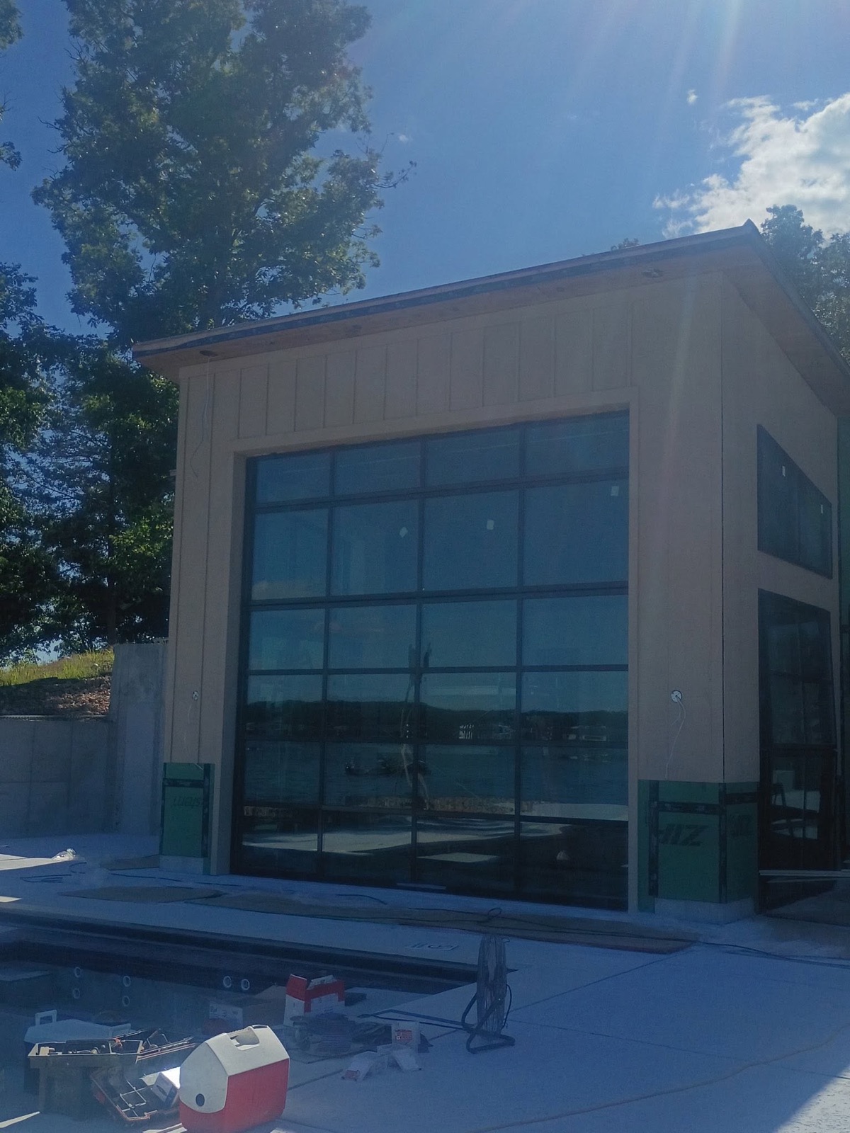 Custom lakeside boathouse with a full-glass overhead door built by Ireland Construction at Lake of the Ozarks