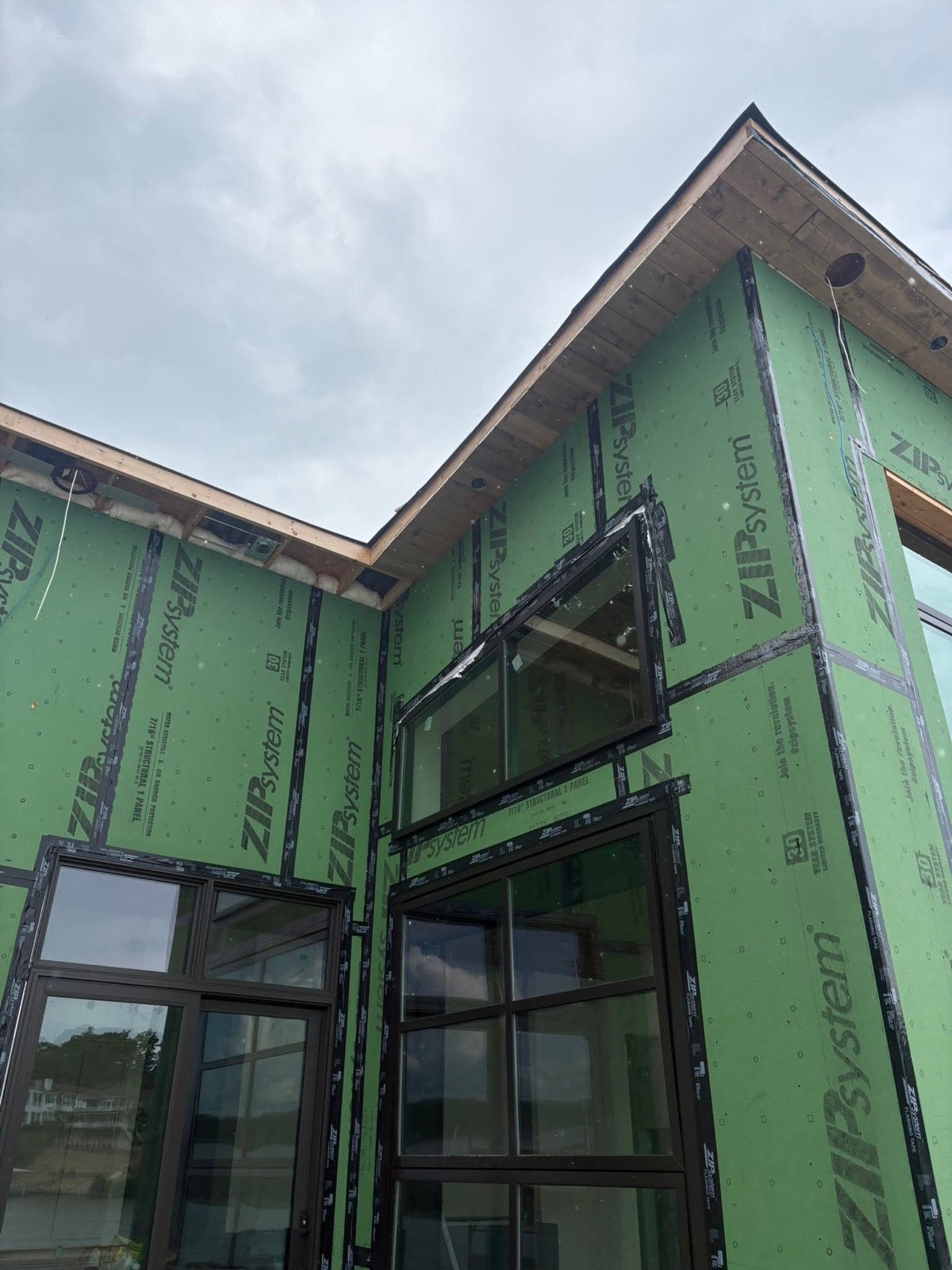 Custom lakefront home under construction with new windows and weather sealing by Ireland Construction
