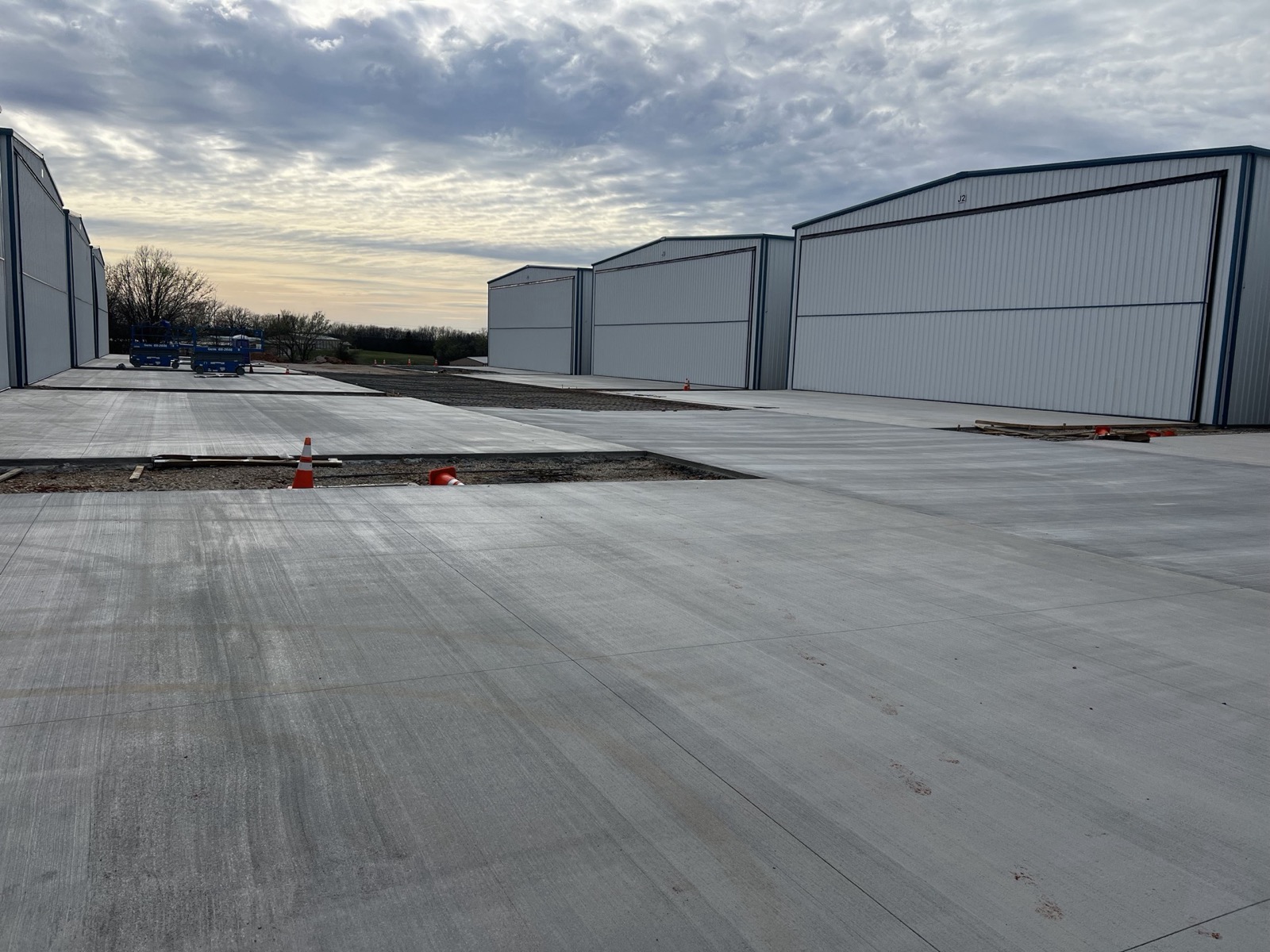 Freshly poured concrete aprons between rows of metal hangars by Ireland Construction