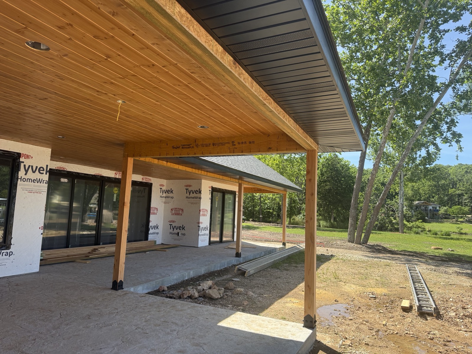 Covered porch with timber posts and a tongue-and-groove pine ceiling on a new custom home by Ireland Construction in the Lake of the Ozarks area